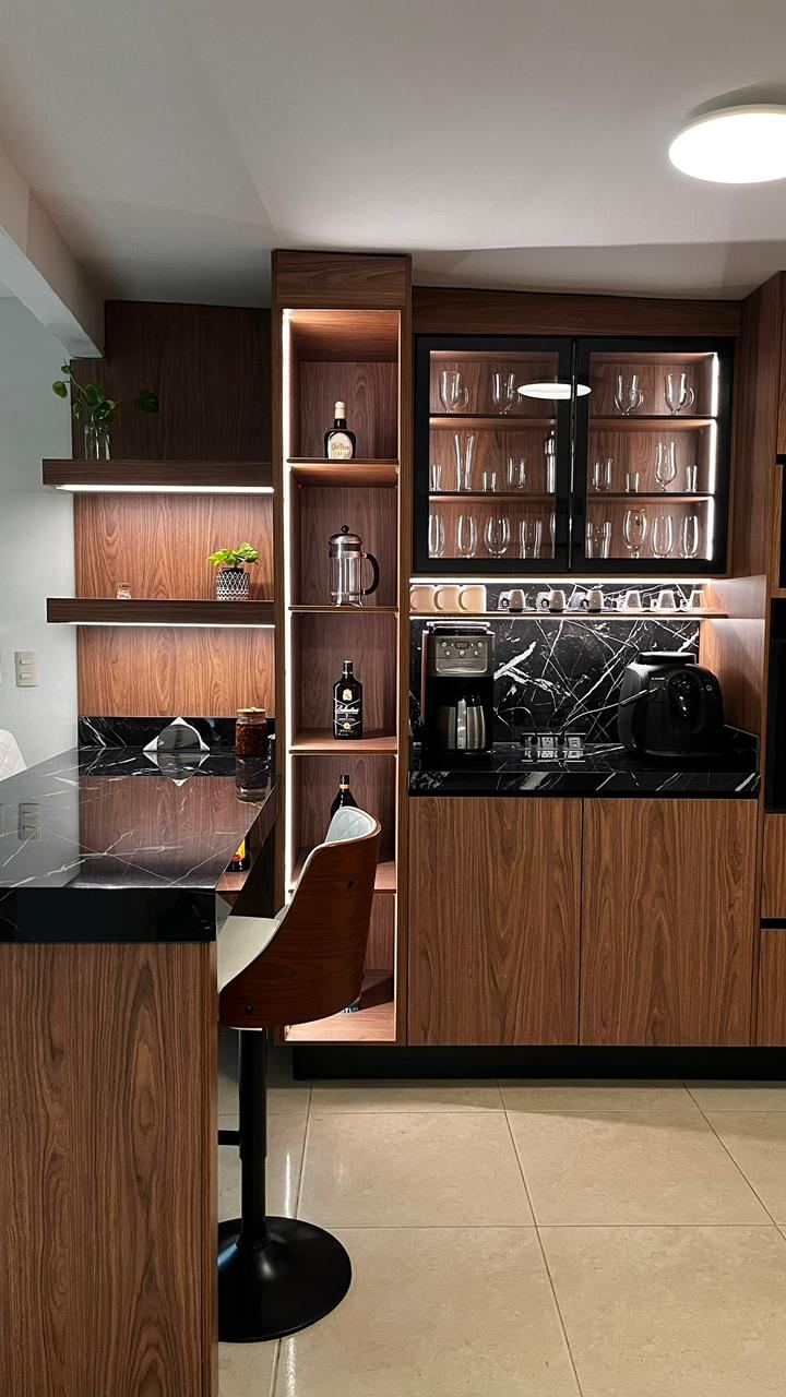 Cocina con alacenas altas de madera con vitrinas iluminadas